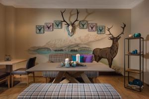 a dining room with a table and deer on the wall at Bayern Resort Hotel - Adults only - mit Zugspitzblick - Eibsee-Nähe - Wellnessbereich - Naturpool im Sommer in Grainau