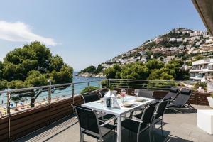 een tafel op een balkon met uitzicht op het strand bij Vista Roses Mar - El Molí in Roses