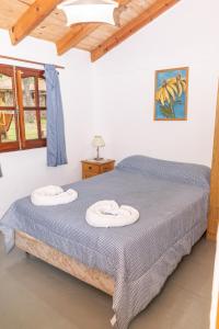 a bedroom with a bed with two towels on it at Tacuifi I - Cabañas in Los Reartes