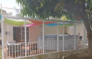 a house with a balcony with a colorful umbrella on it at Family Getaway with Private Parking & Swimming Pool in Carolina