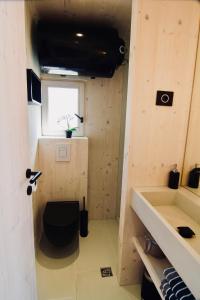 a bathroom with a toilet and a sink and a window at MODERN BEACH VILLAS - Buqez Camp resort in Drage