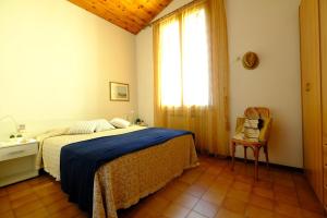 a bedroom with a bed and a window and a chair at Caterina Vista Mare - Pineto Vacanza in Pineto