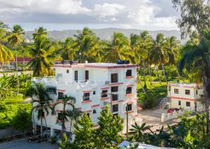 un edificio bianco con palme sullo sfondo di Hotel Turístico Marian a Las Terrenas