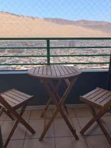 uma mesa e 2 cadeiras numa varanda com vista em Magnolia apart Con facturas em Iquique