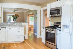 a kitchen with white cabinets and a stove top oven at Lovely House near Downtown, Home away from Home! in Chico