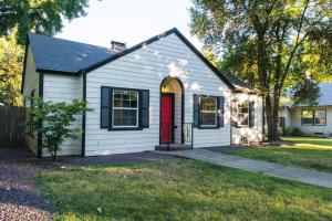 a white house with a red door at Lovely House near Downtown, Home away from Home! in Chico