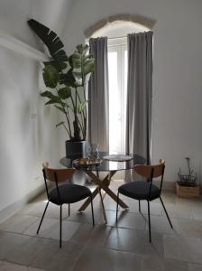 a dining room with a table and chairs and a plant at Caterina's Suites & Apartament in Ostuni