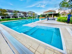 uma piscina com água azul em frente a uma casa em Faizal Madhi Homestay em Kuching