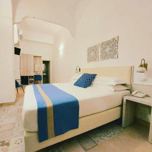 una camera con un grande letto e una scrivania di Hotel Guarracino a Capri