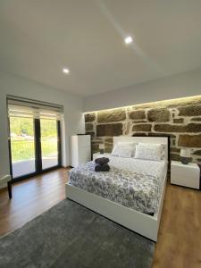 a bedroom with a bed and a brick wall at Casa da Carreira in Mondim de Basto