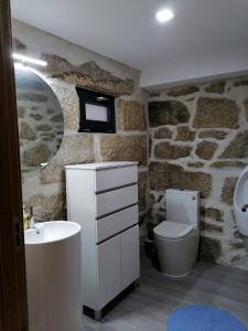 uma casa de banho com um WC branco e um lavatório. em Casa da Carreira em Mondim de Basto