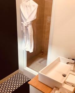 ein Bad mit einem Waschbecken und einer Dusche mit einem Spiegel in der Unterkunft Atipyc Nimes in Nîmes