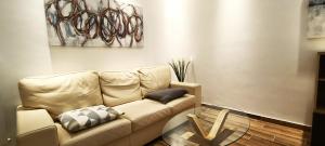 sala de estar con sofá y mesa de cristal en Casa mia Metro A 100mt, en Roma