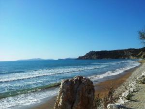 a beach with a large rock on the shore at PORTO-FINO in Arillas