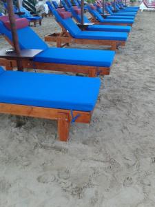 una fila di sedie a sdraio blu sulla spiaggia di PORTO-FINO a Arillas