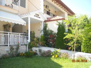 a house with a balcony and flowers in the yard at Zoe's Studios in Parga