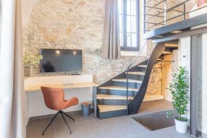 uma escada num quarto com uma secretária e uma cadeira em Les Tours Carrées em La Motte-Servolex