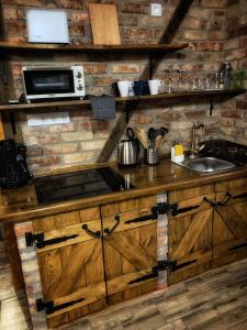 a kitchen with wooden cabinets and a counter top at Mátrai Vadászház 3-Vintage Cottage in Mátraterenye
