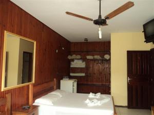 1 dormitorio con 1 cama y ventilador de techo en Pousada do Ipê, en São Lourenço