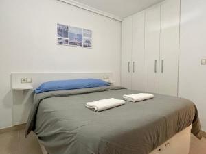 ベニドルムにあるPayma Apartments Benidormのベッドルーム1室(ベッド1台、タオル2枚付)