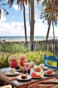 a table with food on it with a view of the beach at Siri Paraiso Hotel in Touros