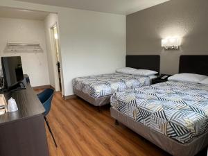 um quarto de hotel com duas camas e uma televisão de ecrã plano em Motel 6-Longview, TX em Longview