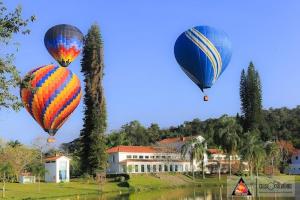 Tres globos de aire caliente están volando sobre una casa en Pousada do Ipê, en São Lourenço