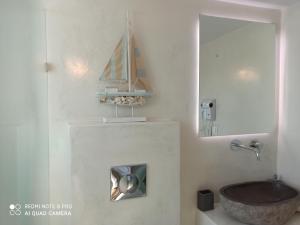 un bagno con lavandino e specchio di Kleri's apartments 6 a Città di Tinos