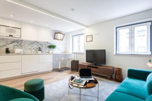 sala de estar con sofá azul y TV en Embaixador Apartments&Suites en Lisboa