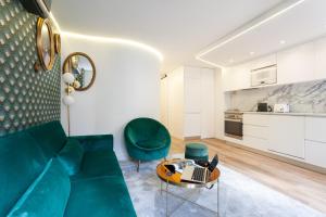 リスボンにあるEmbaixador Apartments&Suitesのリビングルーム(緑のソファ、テーブル付)