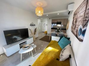 uma sala de estar com um sofá e uma televisão de ecrã plano em Superbe appartement idéalement situé à Cannes em Cannes