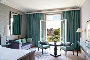 a hotel room with a bed and a window at Le Grand Hotel de Cabourg - MGallery Collection in Cabourg