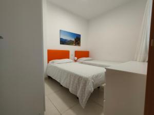 a bedroom with two beds and an orange headboard at Casa Las Canteras in Las Palmas de Gran Canaria