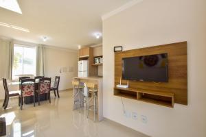 ein Wohnzimmer mit einem Flachbild-TV an der Wand in der Unterkunft Apartamento a 3 min do mar nos Ingleses Norte P154 in Florianópolis