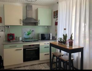 a kitchen with a table and a stove and a microwave at Maison cosy à Ury in Ury