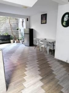 a room with a table and chairs and a refrigerator at Black & White casa privada con alberca in Monterrey