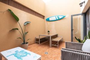 a room with a table and a surfboard on the wall at Casa Cotillo 13 next to Los Lagos Beach Highspeed Wifi in El Cotillo