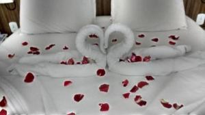 Twee mannen die zoenen op een bed met harten. bij Lacqua diroma - Descanso Merecido, Park aquático 24h, Piscina de Ondas Exclusiva in Caldas Novas +118 foto's