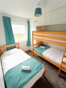 a bedroom with two bunk beds and a window at 35 Gower Holiday Village in Reynoldston