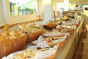 a buffet line with baskets of bread and pastries at Lacqua diRoma Oficial - diRoma Acqua Park Incluído - in Caldas Novas