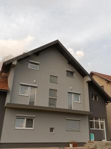 una casa blanca con techo negro en Apartmani Marijamagdalena, en Gračac
