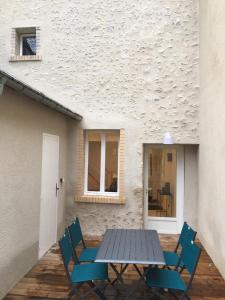 a table and chairs in front of a building at Gîte La Source in Mer