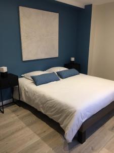 1 dormitorio con 1 cama grande y paredes azules en Gîte La Source, en Mer