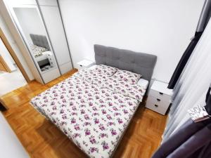 a small bedroom with a bed and a mirror at Apartman Delic in Trebinje