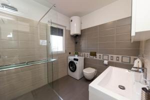 a bathroom with a washing machine and a sink at Deluxe Apartment Stunning view in Jadranovo +52 photos