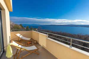 a balcony with a chair and a table and water at Deluxe Apartment Stunning view in Jadranovo