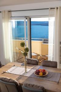 a dining room table with a plate of fruit on it at Deluxe Apartment Stunning view in Jadranovo