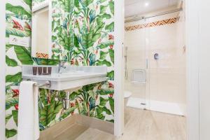 Łazienka z umywalką i tropikalnymi tapetami w obiekcie Espectacular casa de 6 dormitorios, 7 banos y 2 terrazas w Sewilli