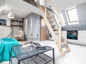 ein Wohnzimmer mit Glastisch und Wendeltreppe in der Unterkunft Słoneczne Studio z widokiem na morze in Sopot