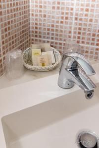 un lavabo avec un robinet et un panier de savon dans l'établissement Logis Auberge Le Colombien - Hôtel et Restaurant, à Villandry